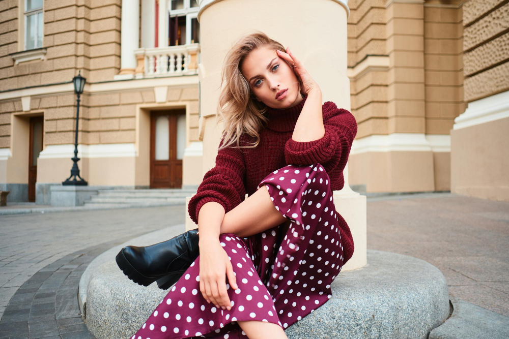 Femeie cu fustă cu buline, așezată în decor urban elegant
