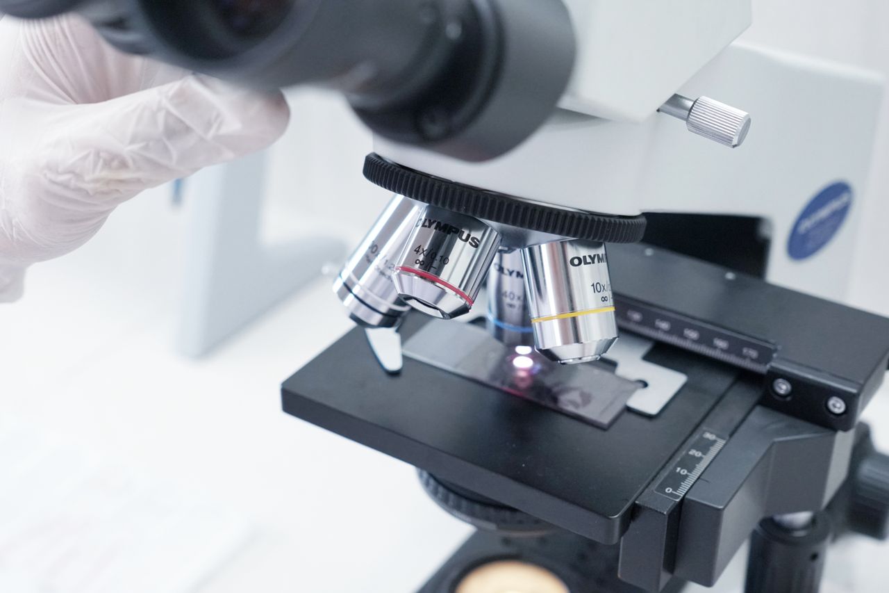 Microscop de laborator analizând probă pe lamelă